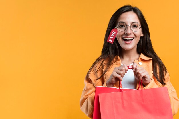 Smileyvrouw die glazen met markering draagt en boodschappentas houdt