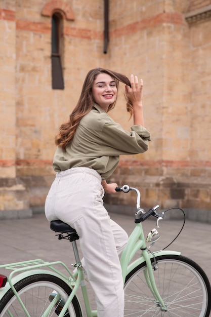 Smileyvrouw die haar fiets in de stad berijdt