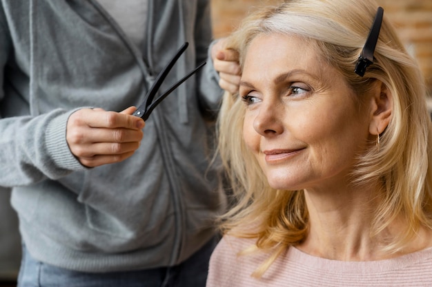 Smileyvrouw die haar kapsel thuis krijgt