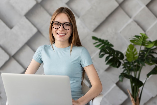 Gratis foto smileyvrouw die met glazen de camera bekijken