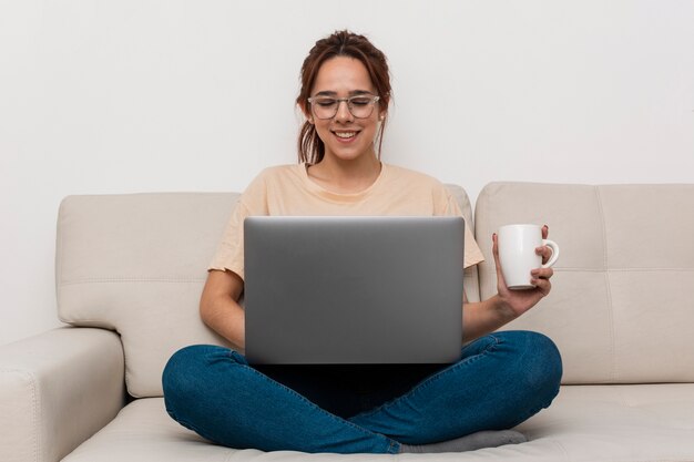 Smileyvrouw die van haar laptop werkt