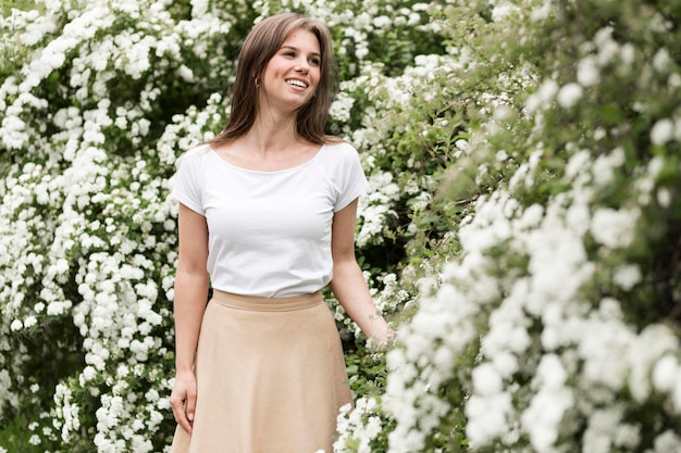 Smileyvrouw die van het portret bloemen bekijkt