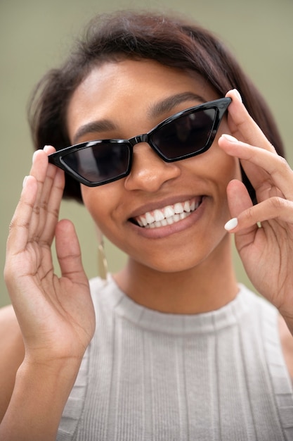 Smileyvrouw die zonnebril dicht omhoog draagt