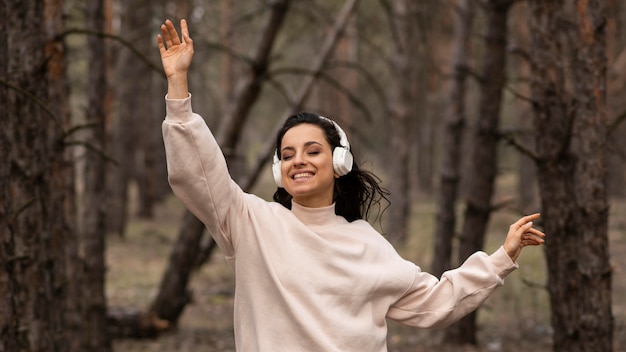 Smileyvrouw het luisteren muziek bij hoofdtelefoons