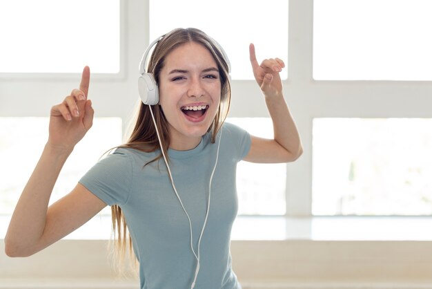 Smileyvrouw het luisteren muziek door hoofdtelefoons