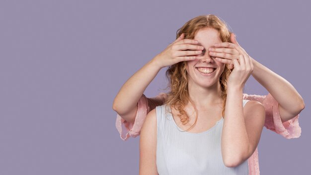 Smileyvrouw het stellen met handen die haar ogen behandelen met exemplaarruimte