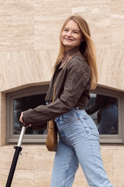 Smileyvrouw in de stad met haar elektrische autoped