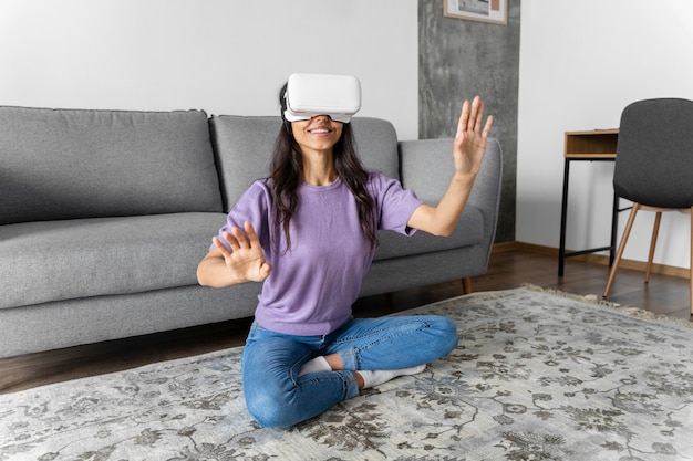Gratis foto smileyvrouw met behulp van virtual reality headset thuis