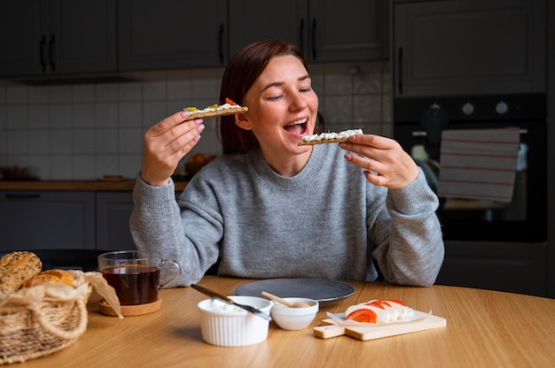 Gratis foto smileyvrouw met heerlijk kaas vooraanzicht