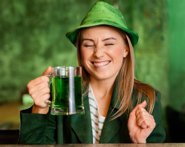 Smileyvrouw met hoed die st. patrick's day met een drankje