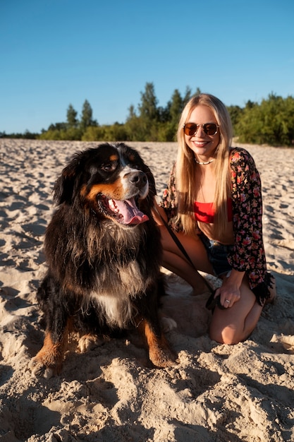 Gratis foto smileyvrouw met leuke hond op strandvooraanzicht