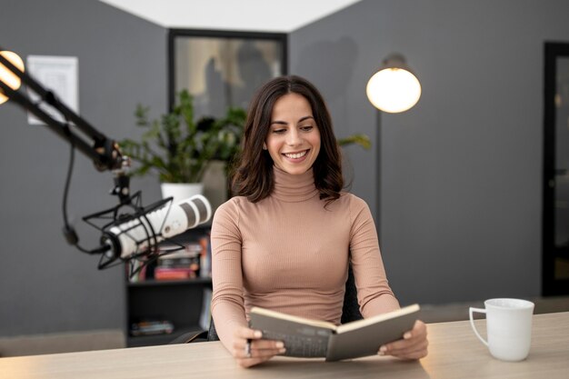 Smileyvrouw met microfoon in een radiostudio