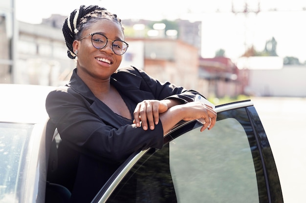 Smileyvrouw poseren naast haar auto