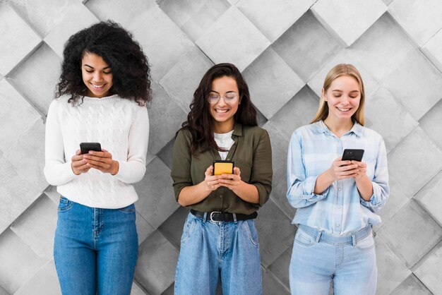 Smileyvrouwen die mobiele telefoons gebruiken