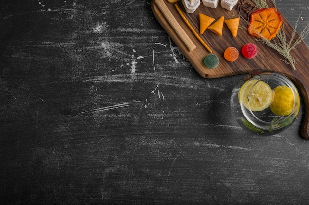 Snack en gebak bord met aardappelen in het water op zwarte achtergrond, bovenaanzicht