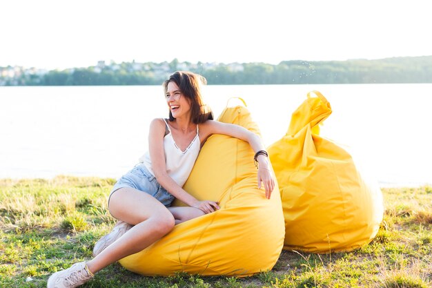 Snak schot het mooie vrouw stellen op gele beanbag