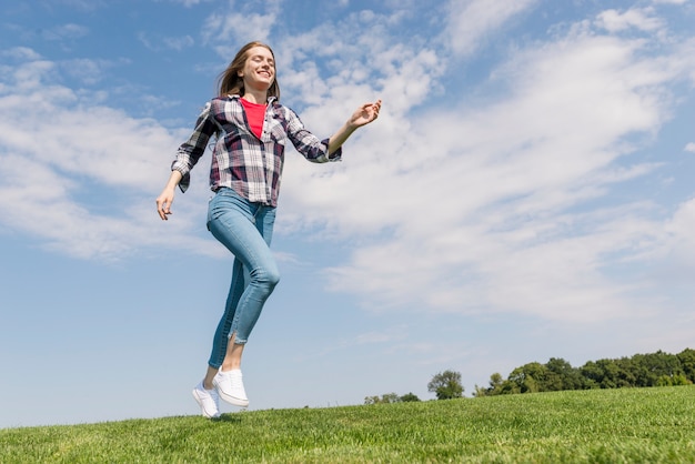 Gratis foto snak schot vrolijk meisje dat op gras loopt