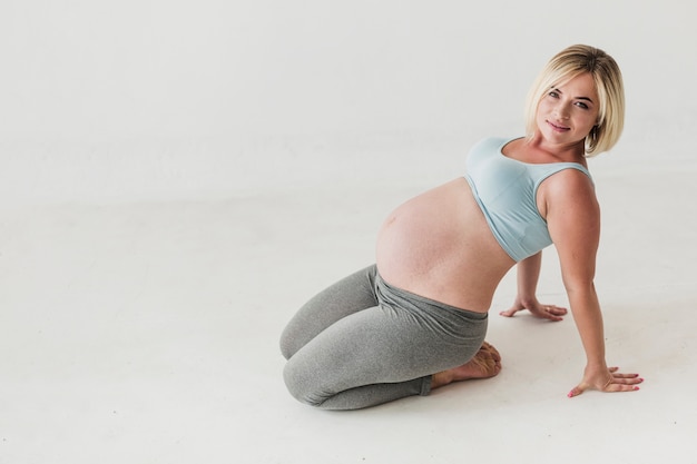 Gratis foto snak schot zwangere vrouw met exemplaarruimte