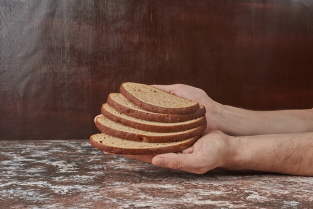 Sneetjes brood in de hand houden.