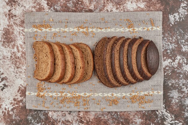 Sneetjes brood op marmer op een stuk handdoek.