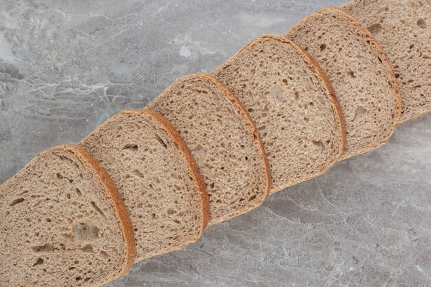 Sneetjes bruin brood op marmeren oppervlak