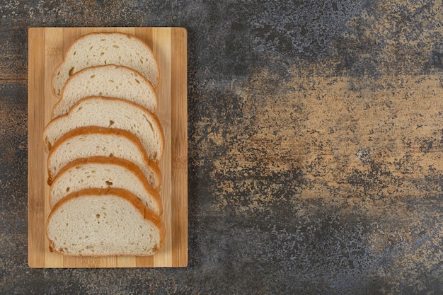 Gratis foto sneetjes wit brood op een houten bord