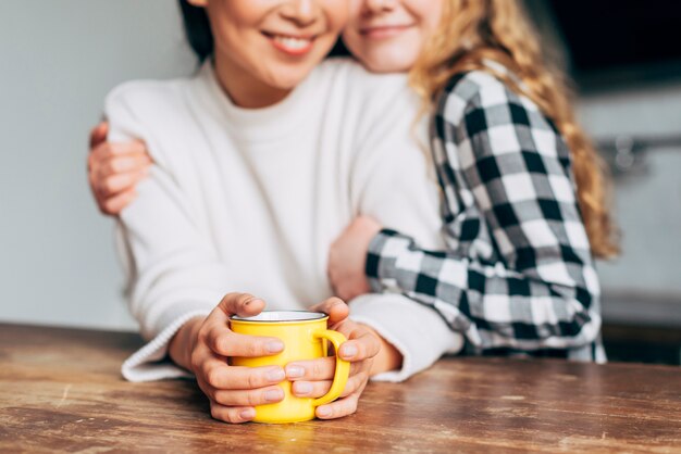 Snij vrouwen knuffelen zittend aan tafel