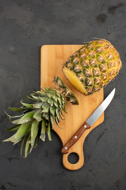 Gratis foto snijd ananas verse zachte sappig op een houten bureau en een grijze achtergrond