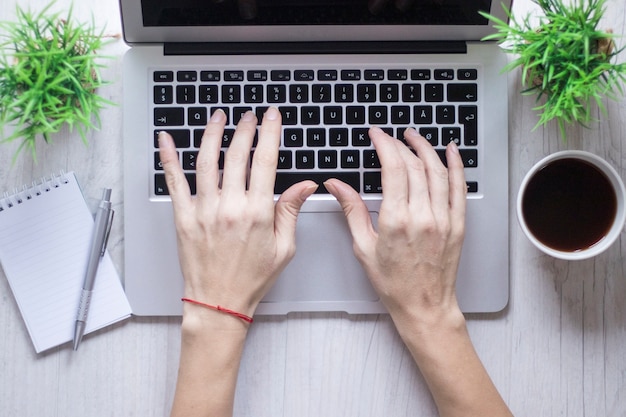 Snijd de hand met behulp van laptop in de buurt van koffie en laptop