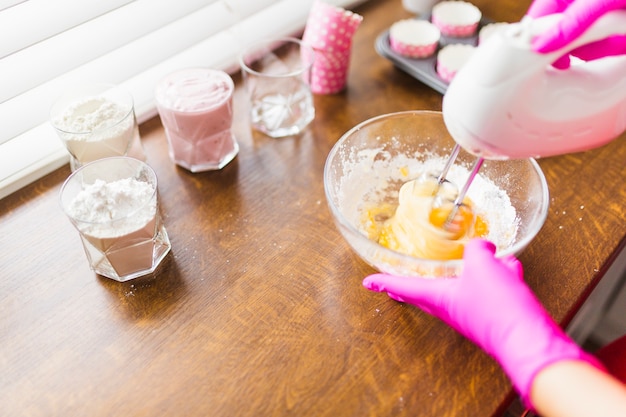 Gratis foto snijd de handen in een mengeling van beslag voor cupcakes