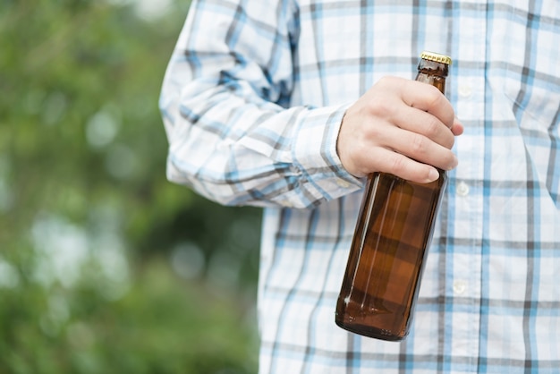 Gratis foto snijd kerel met een fles bier