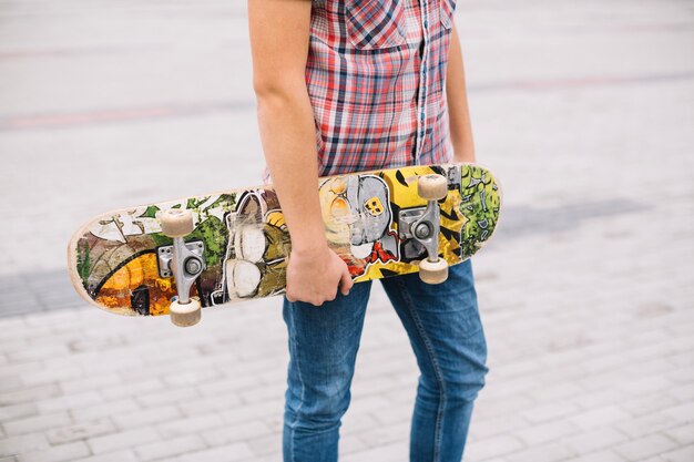 Gratis foto snijd tiener met skateboard