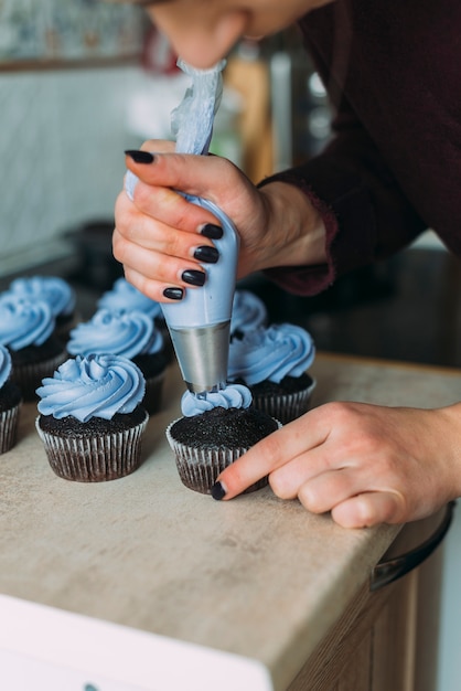 Gratis foto snijd vrouw die muffins verfraait