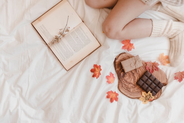 Snijd vrouw en boek in de buurt van chocolade en cadeau