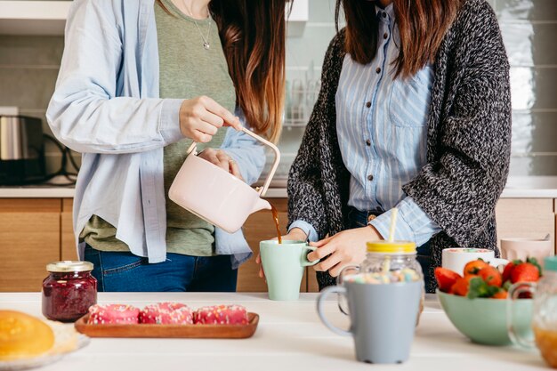 Snijd vrouwen die thee in de keuken gieten