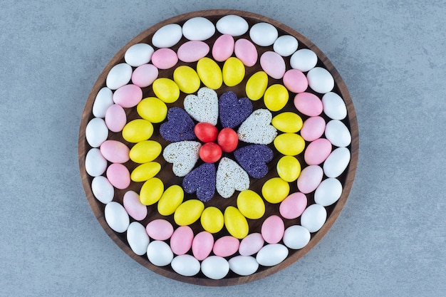 Snoep en koekjes op een rond dienblad, op de marmeren tafel.