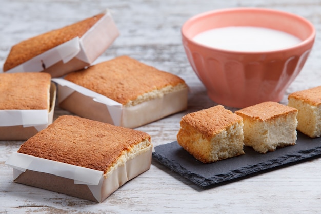 Sobaos pasiegos en een kom melk op een oude houten tafel