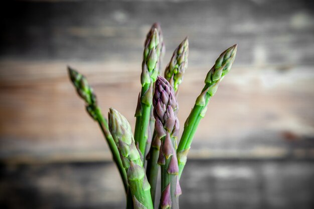 Sommige een bos van asperges op donkere houten achtergrond, zijaanzicht.