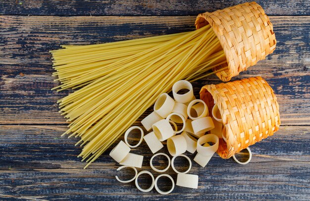 Sommige macaronideegwaren met spaghetti in emmers op donkere houten achtergrond, hoogste mening.