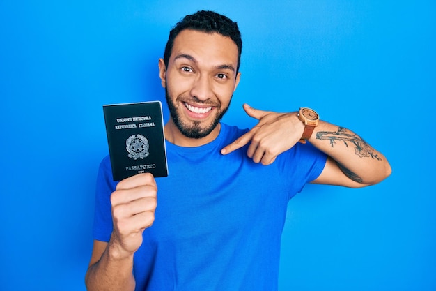 Spaanse man met baard met Italiaans paspoort, zelfverzekerd met een glimlach op het gezicht, zichzelf wijzend met vingers trots en gelukkig.