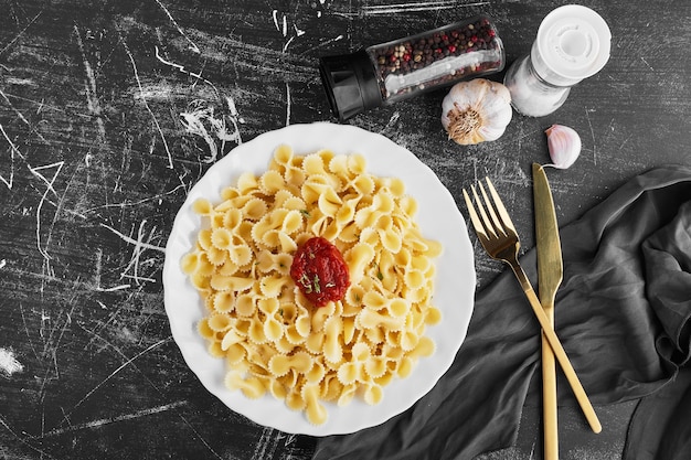 Spaghetti in tomatensaus in een witte plaat, bovenaanzicht.