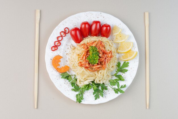 Spaghetti met gehakte kip en groenten op een witte plaat