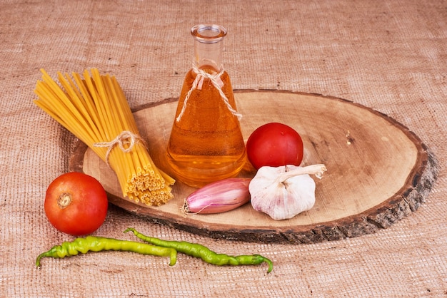 Spaghetti op een houten bord met ingrediënten.