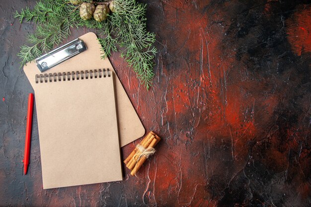 Spar takken kaneel limoenen conifer kegels geschenk en notitieboekje op donkere achtergrond