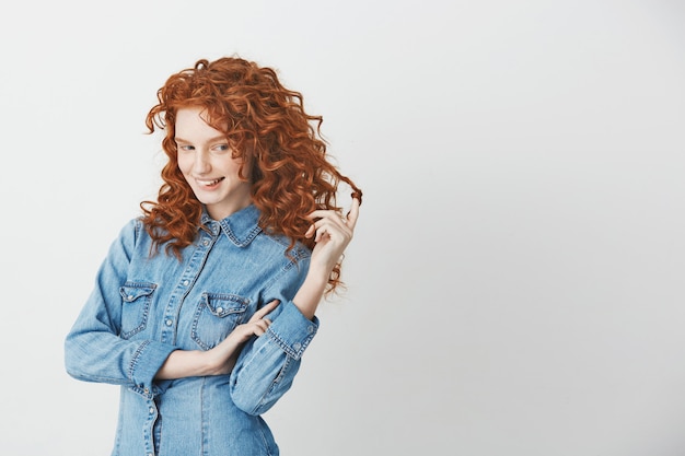 Speels mooi meisje met foxy rood haar denken dromen bijten lippen.