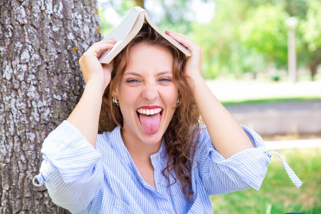 Speels studentenmeisje dat pret in de zomerpark heeft