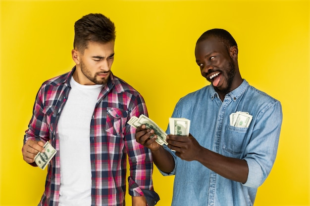 Speelse Afrikaanse man een grapje met mooie Europese man terwijl het bedrijf geld