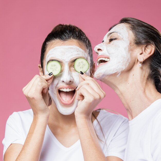 Speelse moeder en dochter met gezichtsmasker