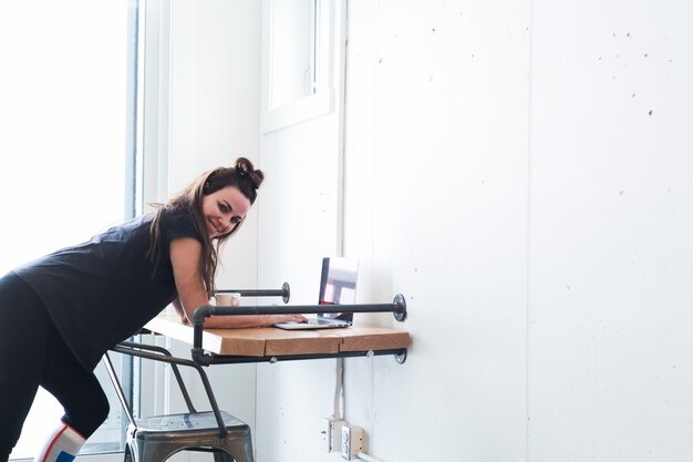 Speelse vrouw aan tafel in de kamer