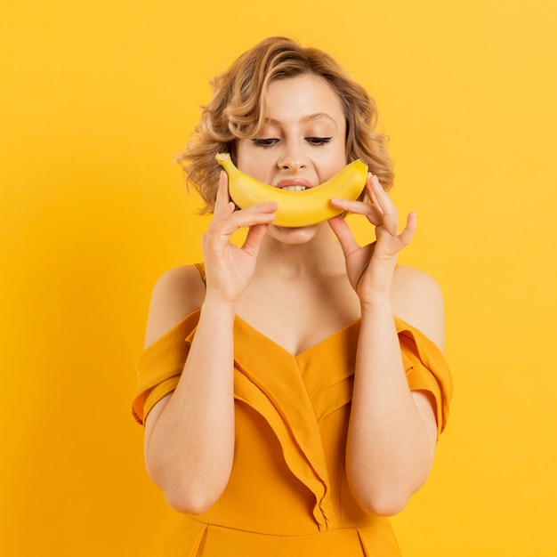 Speelse vrouw die banaan eet